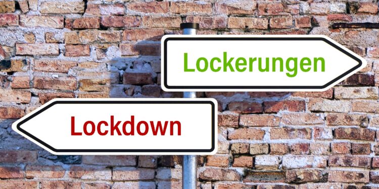 Zwei Straßenschilder: eins hat die Aufschrift "Lockdown", das andere die Aufschrift "Lockerungen".