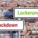 Zwei Straßenschilder: eins hat die Aufschrift "Lockdown", das andere die Aufschrift "Lockerungen".