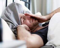 Ein Mann wacht gerade aus dem Schlaf auf.