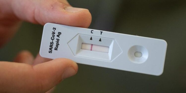 Eine Person hält einen Corona-Selbsttest mit negativem Ergebnis.