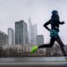 Ein Jogger läuft vor der Skyline von Frankfurt.