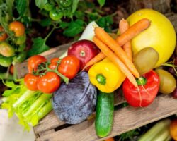 Verschiedene Obst- und Gemüsesorten auf einem Holzbrett.