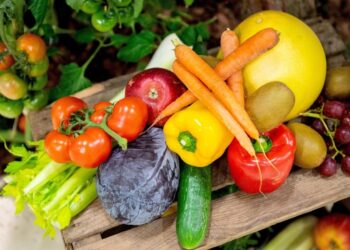 Verschiedene Obst- und Gemüsesorten auf einem Holzbrett.