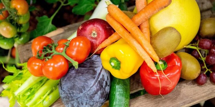 Verschiedene Obst- und Gemüsesorten auf einem Holzbrett.