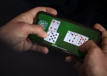 Eine Person spielt ein Kartenspiel auf dem Smartphone.
