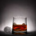 Bild von einem Glas Alkohol mit einen Totenkopf aus Eis daneben.