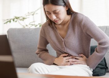 Frau mit Darmkrebs hält sich den Bauch.