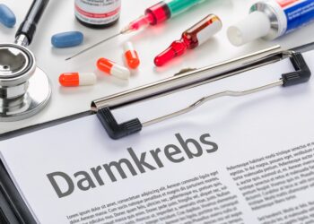 Klemmbrett mit einem Blatt zu Darmkrebs neben Medikamenten