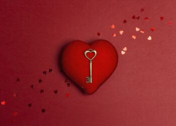 Ein kupferner Schlüssel liegt auf einem roten Herz.