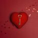 Ein kupferner Schlüssel liegt auf einem roten Herz.