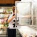 Frau wählt Tiefkühlkost aus einem Supermarkt-Gefrierschrank