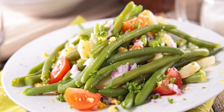 Bunter Salat mit grünen Bohnen auf weißem Teller