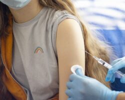 Jugendliche wird in den Oberarm geimpft