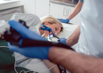 Arzt führt die Kamera von Gastroskop in Mund von Patientin ein