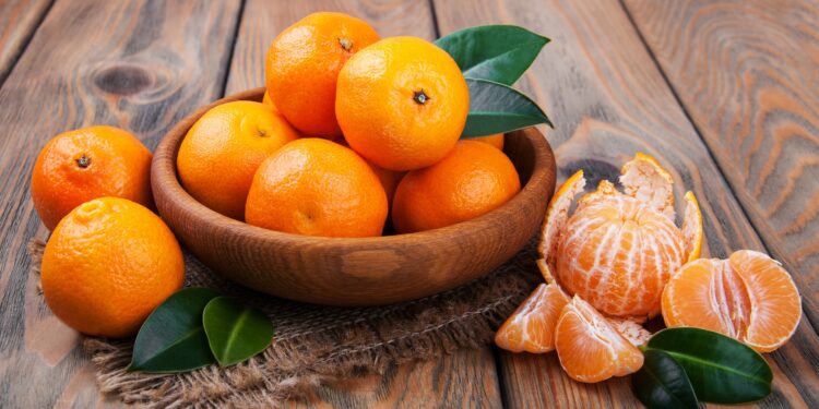 Frische Mandarinen in einer Holzschale auf einem Tisch