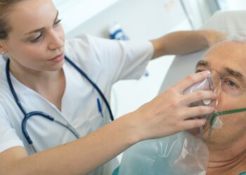 Ärztin setzt Mann Sauerstoffmaske aufs Gesicht