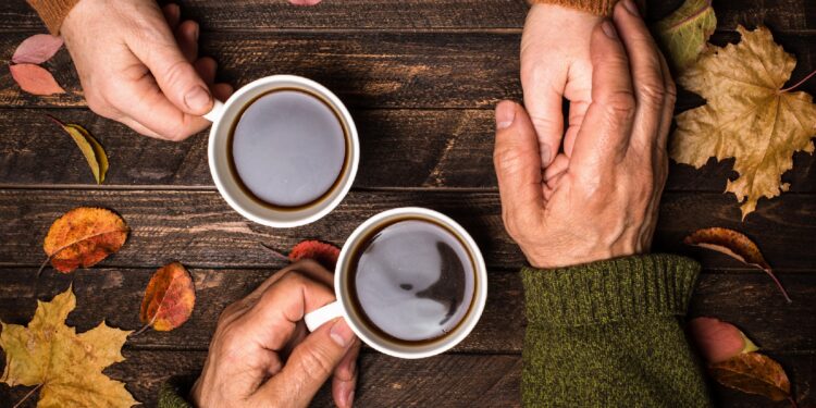 Zwei Tassen Kaffee stehen auf einer hölzernen Oberfläche.