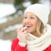 Junge Frau schützt ihrer Lippen mit Lippenbalsam vor der Kälte