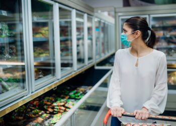 Eine Frau betrachtet Tiefkühl-Ware im Supermarkt.