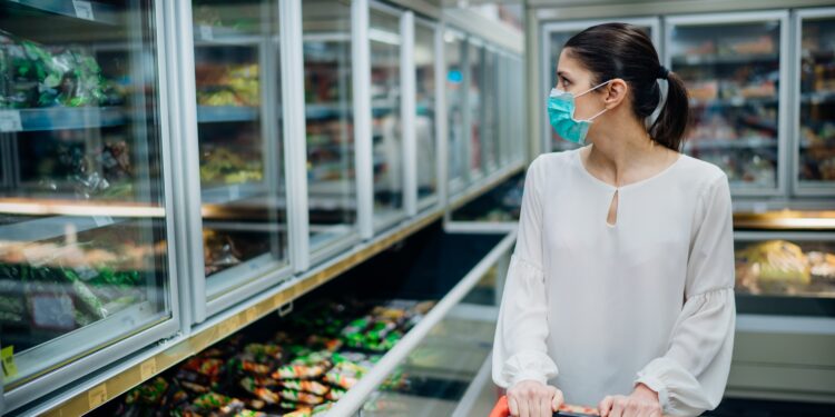 Eine Frau betrachtet Tiefkühl-Ware im Supermarkt.