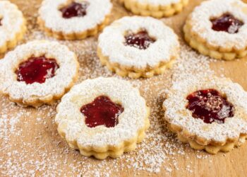 Weihnachtsplätzchen gefüllt mit mit Marmelade auf bemehltem Tisch