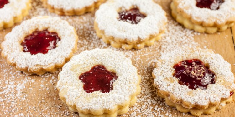 Weihnachtsplätzchen gefüllt mit mit Marmelade auf bemehltem Tisch