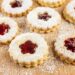 Weihnachtsplätzchen gefüllt mit mit Marmelade auf bemehltem Tisch