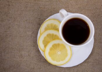 Eine Tasse schwarzer Kaffee mit Zitronenscheiben