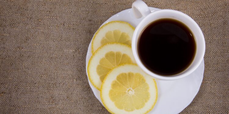 Eine Tasse schwarzer Kaffee mit Zitronenscheiben