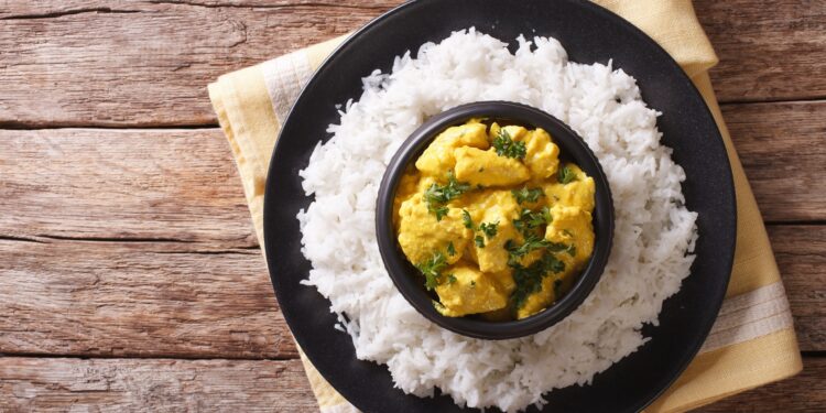 In einer Schüssel ist das indische Gericht Korma mit Reis angerichtet.