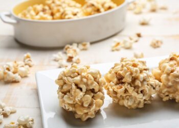 Gebackene Popcorn-Bällchen sind auf einer weißen Platte angerichtet.