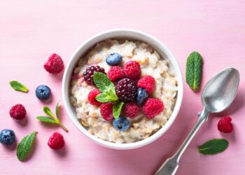 Eine Portion Porridge mit Früchten ist ein einer weißen Schüssel angerichtet.