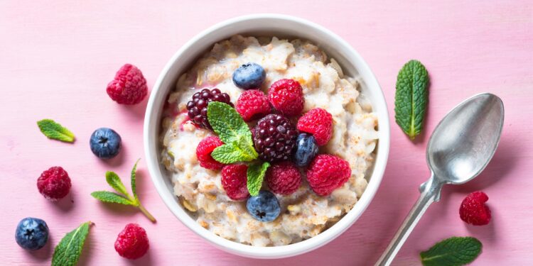 Eine Portion Porridge mit Früchten ist ein einer weißen Schüssel angerichtet.