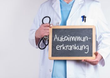 Arzt mit einer Tafel mit der Aufschrift Autoimmunerkrankung