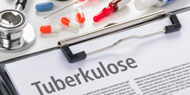 Klemmbrett mit einem Zettel zu Tuberkulose neben diversen Medikamenten