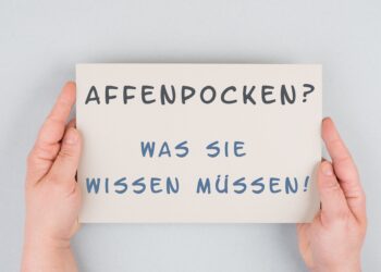 Zwei Hände halten ein Schild mit der Aufschrift: Affenpocken? Was Sie wissen müssen!