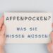 Zwei Hände halten ein Schild mit der Aufschrift: Affenpocken? Was Sie wissen müssen!