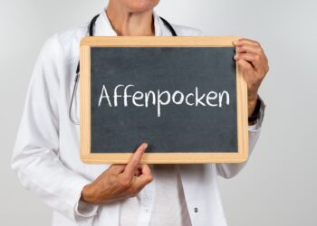 Ärztin zeigt auf eine Tafel auf der Affenpocken steht