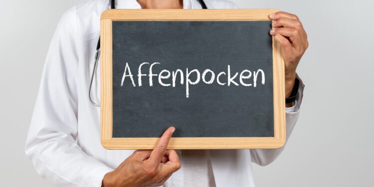 Ärztin zeigt auf eine Tafel auf der Affenpocken steht