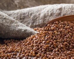 Buchweizen und ein Holzlöffel in einem Leinensack