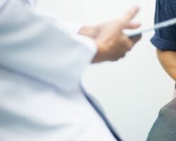 Mann bei der ärztlichen Untersuchung bedeckt mit den Händen seinen Genitalbereich