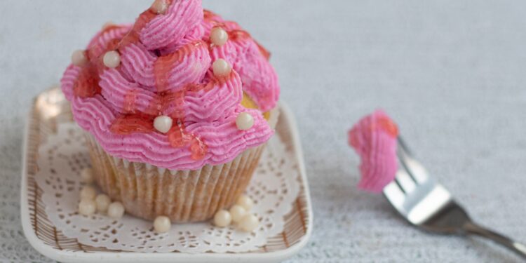 Rosafarbener Muffin auf einem kleinen Teller