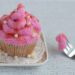 Rosafarbener Muffin auf einem kleinen Teller