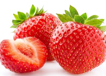 Drei rote Erdbeeren mit grünen Blättern vor weißem Hintergrund