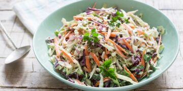 Eine Portion Coleslaw ist auf einem grünen Teller angerichtet.