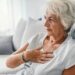 Eine ältere Frau mit Sodbrennen fasst sich an die Brust