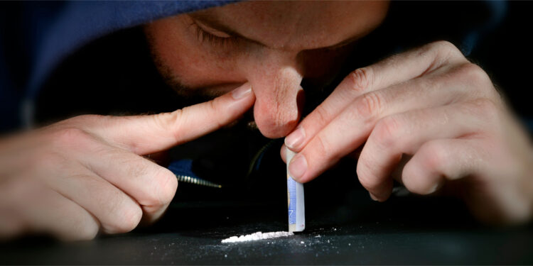 Junger Mann schnupft kokain
