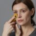 Frau reibt ein Stück Bananenschale über ihr Gesicht