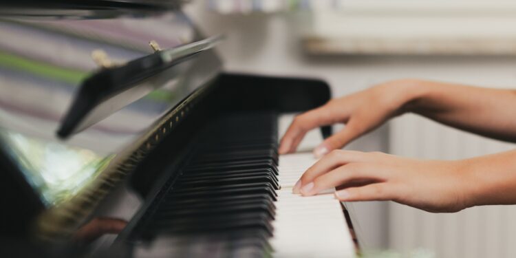 Eine Frau spielt auf einem Klavier.