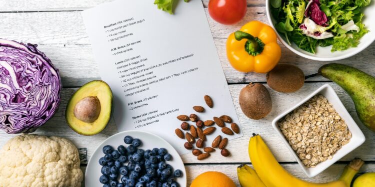 Ein Diät-Plan ist von gesunden Lebensmittelmitteln umgeben.
